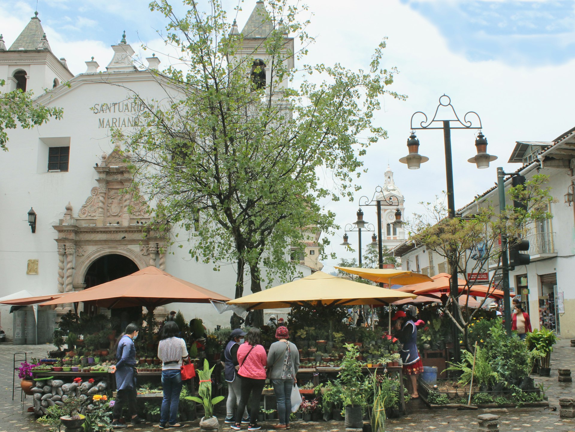 a group of people standing around tables with umbrellas